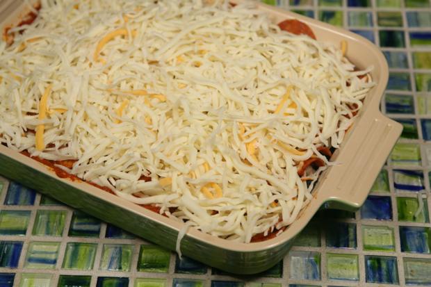 Sprinkle the pizza cheese over the sauce.
