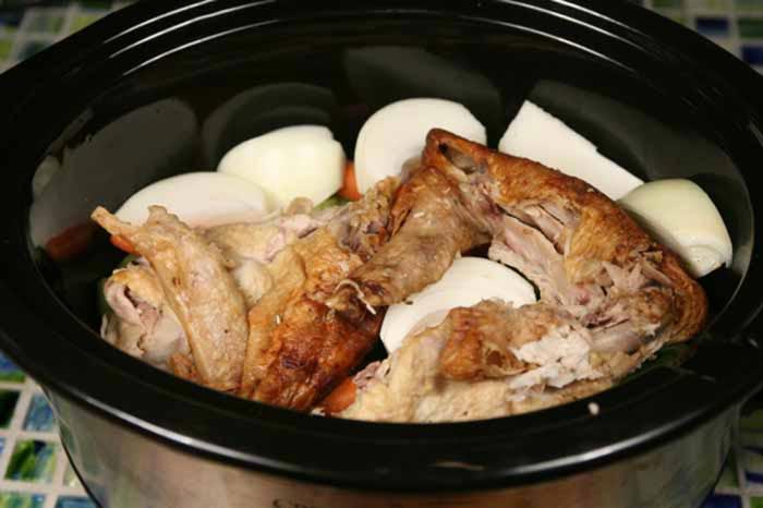 Add the turkey, celery, carrots, onion, bay leaves, and thyme to a slow cooker.