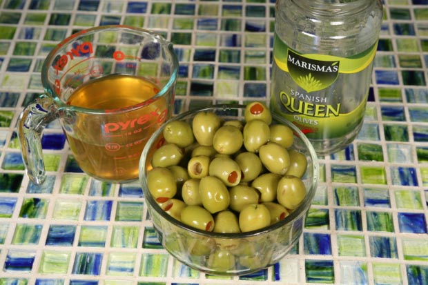 Drain the olives and pour the brine into a measuring cup to reserve for later.